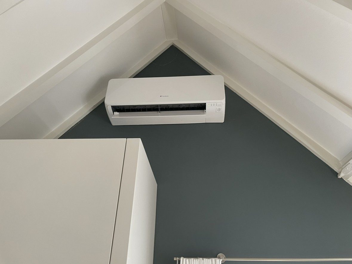 Witte Fuji Electric binnenunit onder een schuin dak